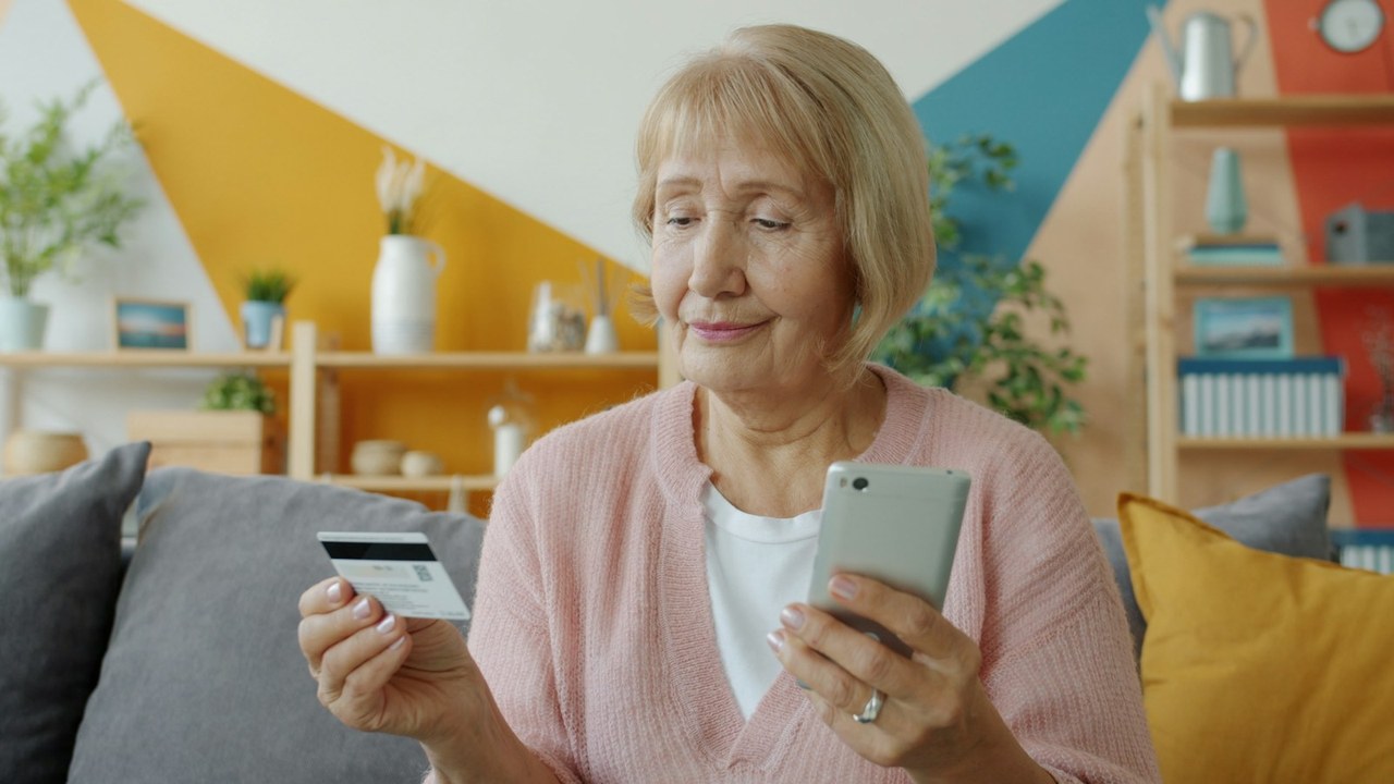 Denise chez elle, sa carte dans une main et son téléphone dans l’autre, photo Vitaly Gariev sur Unsplash
